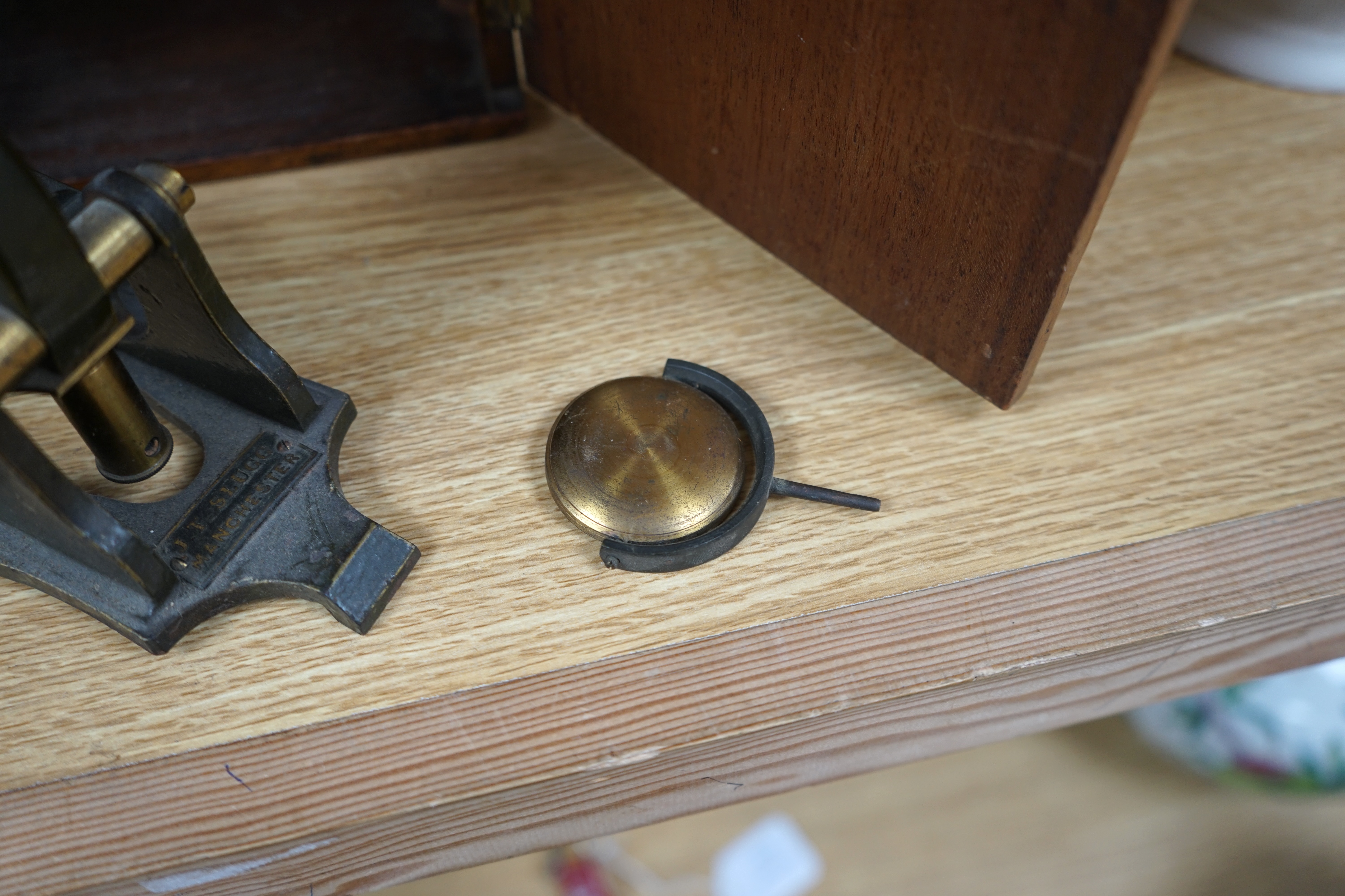 A Victorian brass microscope, J T Slugg, Manchester, in original wooden case, with a small selection of slides. Condition - fair, untested